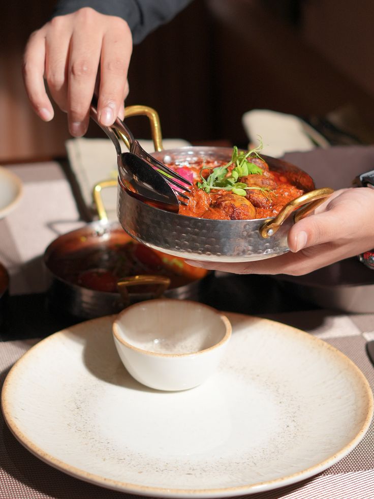 Chicken handi served tableside in a copper pot